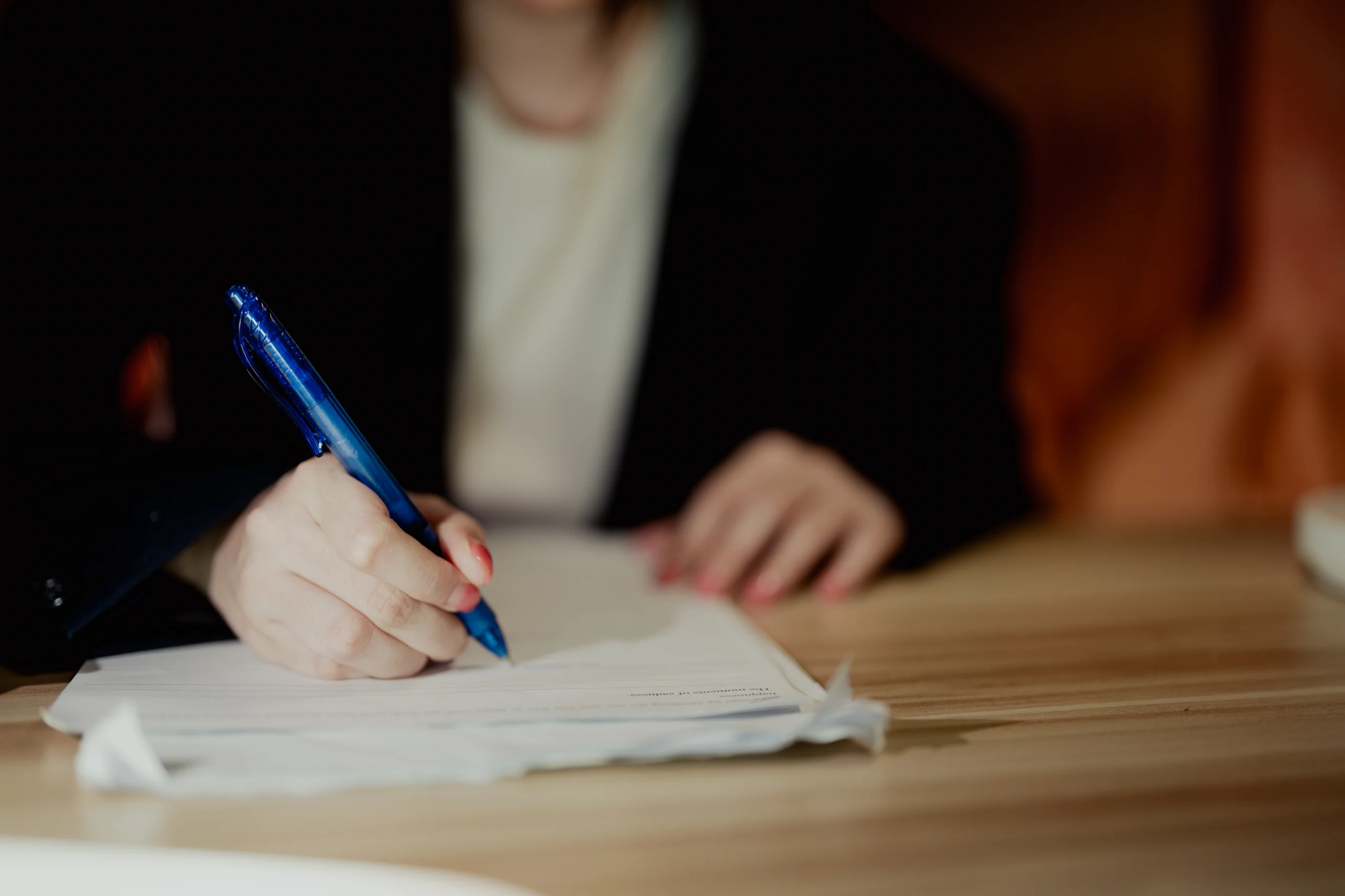 Applicant signing a paper permit application form at a desk